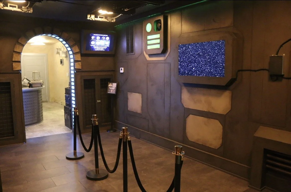 Inside Docking Bay 316: sculpted bulkhead panels, a lit starfield display and the illuminated archway through to the ordering counter